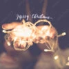 Fotografia Merry Christmas Glowing Word Over Hand With Party Light String Bokeh In Vintage Filter,Holiday, New Year Season