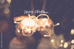 Fotografia Merry Christmas Glowing Word Over Hand With Party Light String Bokeh In Vintage Filter,Holiday, New Year Season